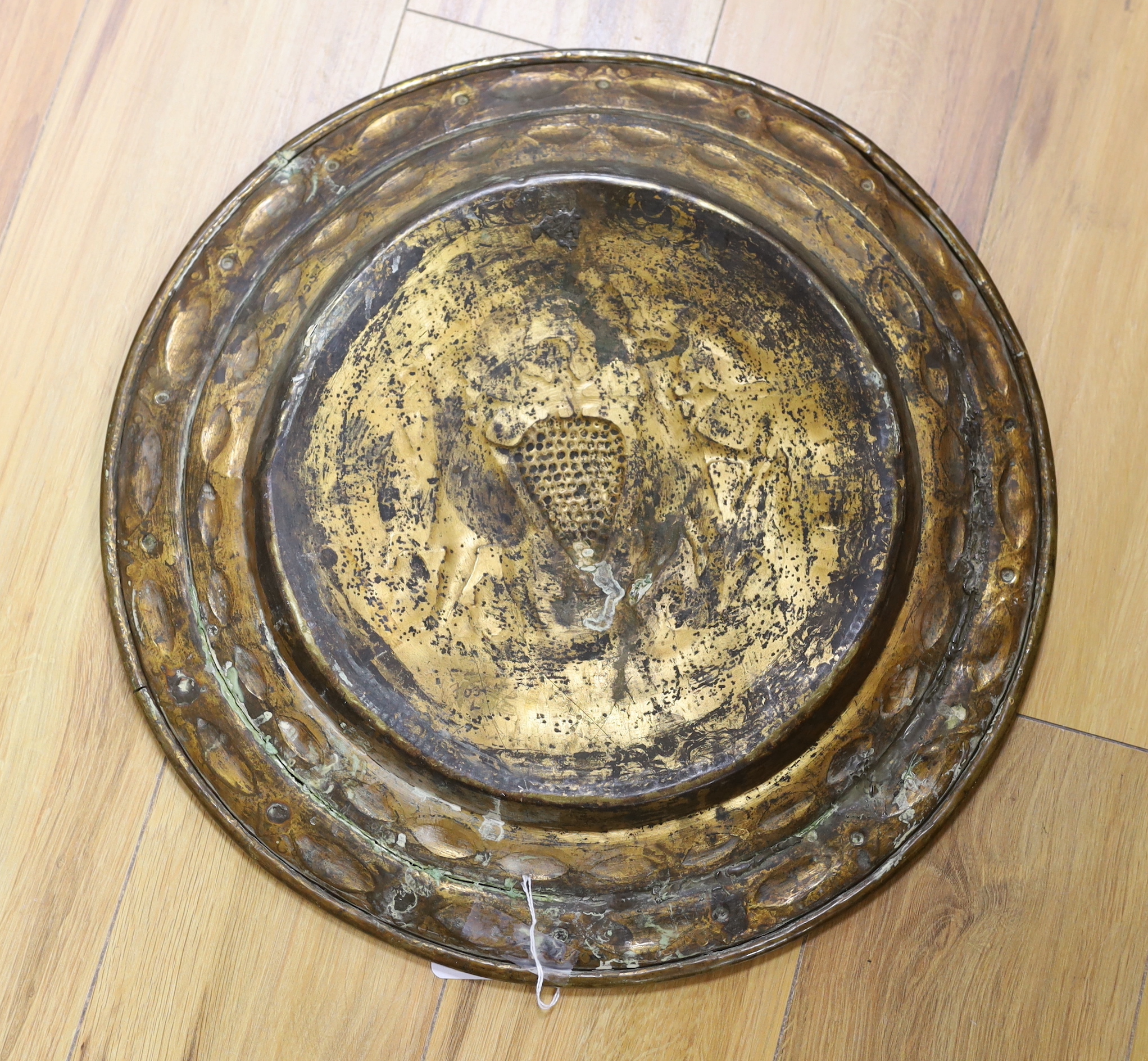 A brass Nuremberg Alms dish embossed with two figures, signed F Reimet Dreyers, 47cm in diameter